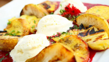 Brzoskwinie, gruszka i ananas z rusztu na sosie ze świeżych malin z lodami waniliowymi